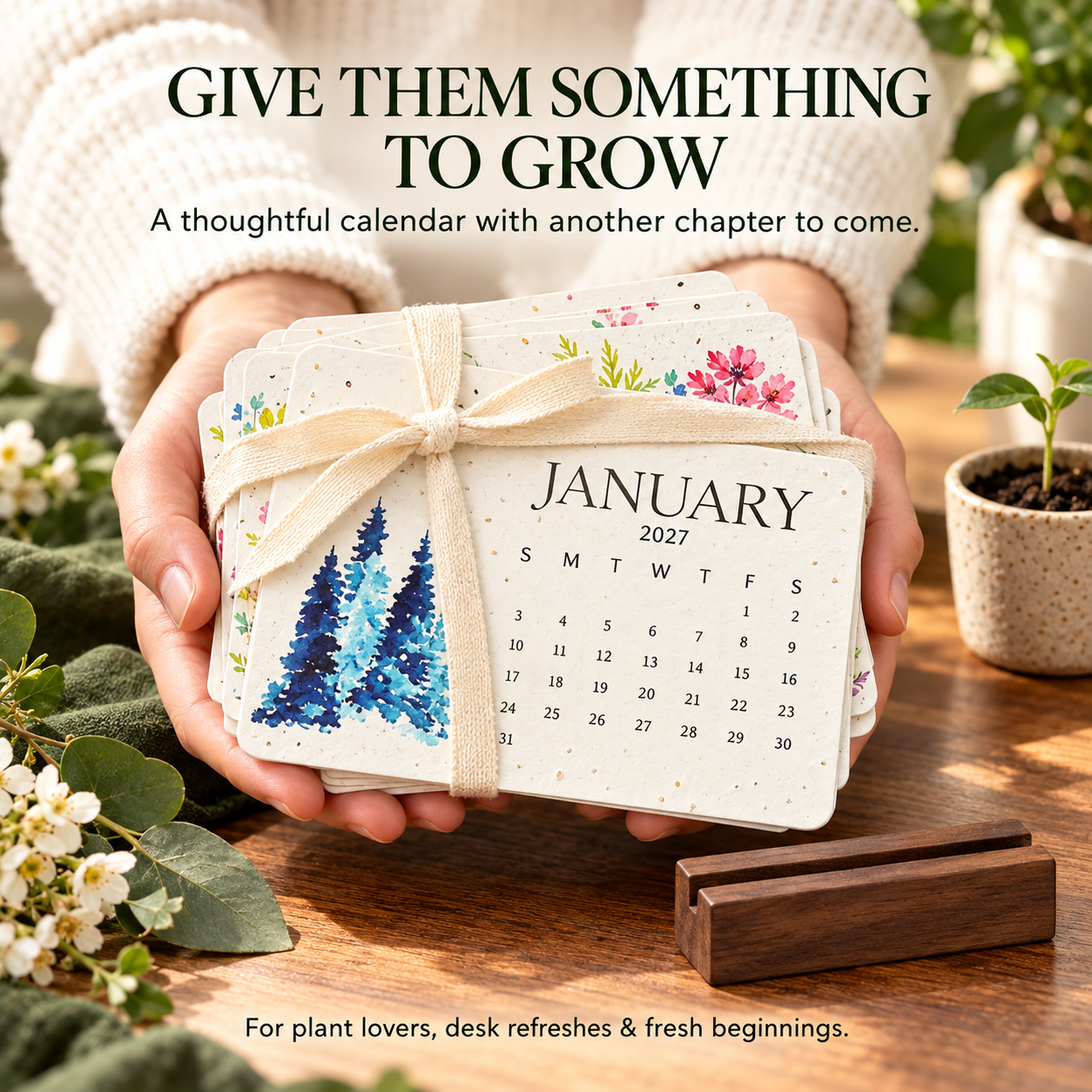 Person holding a ribbon-tied set of plantable 2027 calendar cards as a thoughtful gift